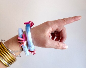 Shibori fabric bracelet with pink shell beads hand dyed indigo and stitched on cotton fabric with pink stitching An Astrid Endeavor Spring