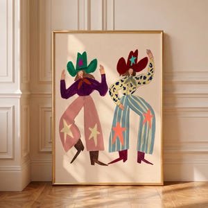 May include: A framed art print featuring two figures in cowboy hats. The left figure wears a green hat, purple shirt, and pink pants with yellow stars. The right figure wears a red hat, leopard print shirt, and blue striped pants with orange stars.
