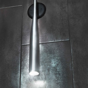 May include: A silver baseball bat-shaped wall sconce with a light bulb at the end. The sconce is mounted on a black circular base against a dark gray tiled wall. The text "ZAL CREATIONS" is visible in the upper right corner of the image.