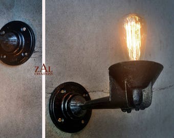 May include: Two black metal wall lights with Edison bulb fittings. The lights have a vintage industrial style.