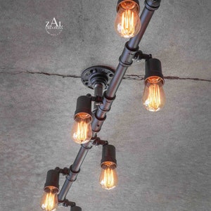 May include: A black metal pipe light fixture with six Edison bulbs. The fixture is mounted to a concrete ceiling.