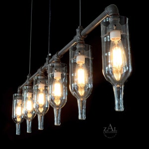 May include: A six-light industrial style chandelier made from repurposed wine bottles and black metal pipe. The chandelier has a rustic look and is perfect for a modern or farmhouse style home.