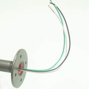 May include: A close-up of a gray metal pipe fitting with three wires coming out of it. The wires are green, black, and white.