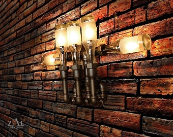 May include: A wall-mounted light fixture made from repurposed glass bottles and metal pipes. The fixture has four light bulbs and is mounted on a brick wall. The light fixture is a unique and industrial-style design.