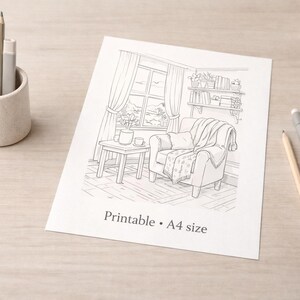 May include: A black and white line drawing of a cozy living room scene, including a window, armchair, and side table. The words "Printable &bull; A4 size" are printed on the paper. A pencil holder with pencils and a pen are on the table.