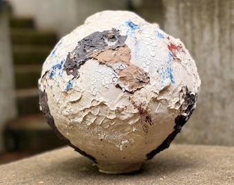 Jarrón lunar de cerámica hecho a mano con superficie muy texturizada.