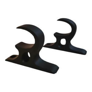 Puede incluir: Dos ganchos de metal negro con un diseño curvo. Cada gancho tiene una base con un agujero y una parte superior curva, adecuada para colgar objetos. Los ganchos están diseñados para montaje en pared.