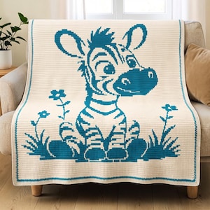 May include: A cream-coloured crochet blanket featuring a large, teal-coloured pixelated graphic of a seated zebra. The zebra is surrounded by small, simple floral and grass motifs. The blanket has a solid teal border along all four edges.