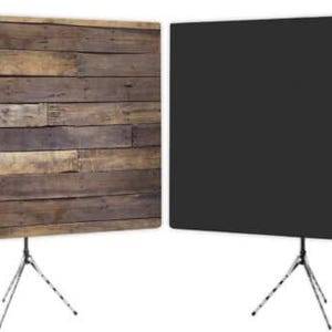 May include: Two photography backdrops. One features a rustic wood plank design, the other is a solid black. Both are mounted on adjustable tripod stands, ideal for studio or on-location photography and videography.