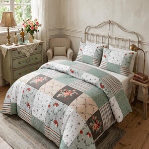 May include: A patchwork quilt and two matching pillowcases on a bed. The quilt features floral patterns in red, pink, and gray on a white and green background. The bed is in a room with a window and a small rug.