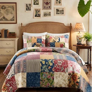 Puede incluir: Un edredón patchwork y fundas de almohada a juego en un dormitorio. El edredón presenta una variedad de patrones florales y geométricos en tonos rojos, azules y amarillos. La cama tiene un cabecero tejido y está sobre un suelo de madera con una alfombra estampada.