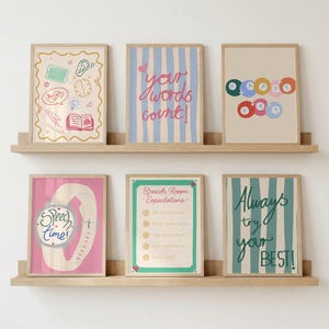 Può includere: Sei stampe artistiche incorniciate disposte su due mensole in legno. Le stampe presentano temi educativi con illustrazioni di un cervello, un orecchio e un libro, e testi che recitano "your words count!", "HAPPY DAY", "Speech time!", "Speech Room Expectations" e "Always try your BEST!" in vari colori.