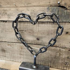 Puede incluir: Una taza de cerámica blanca con un asa negra y el texto "But First, Coffee" en negro, con una fuente de estilo manuscrito. La taza está sobre una superficie blanca.