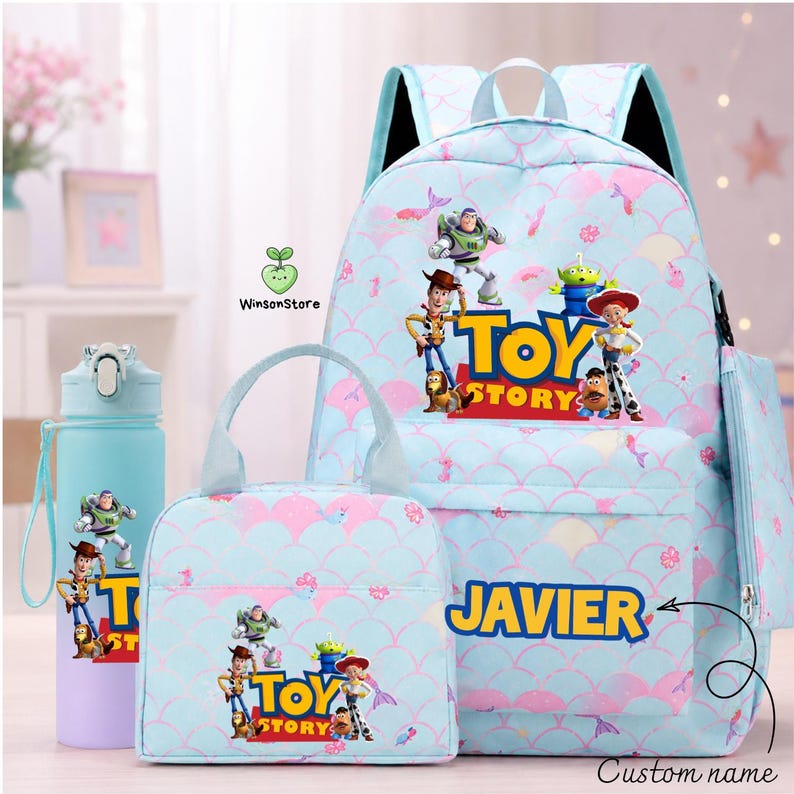 May include: A light blue backpack, lunch bag, and water bottle set featuring a Toy Story print with characters like Woody, Buzz Lightyear, and Jessie. The backpack and lunch bag display the name JAVIER in yellow text and a repeating scale pattern.
