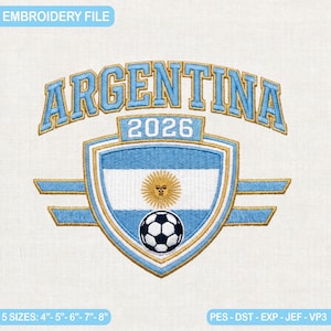 Puede incluir: Un diseño de bordado con la palabra ARGENTINA en azul claro con bordes dorados, arqueada sobre un escudo que contiene el año 2026, el emblema del sol de mayo y un balón de fútbol. Disponible en tamaños de 10,16 cm, 12,7 cm, 15,24 cm, 17,78 cm y 20,32 cm.