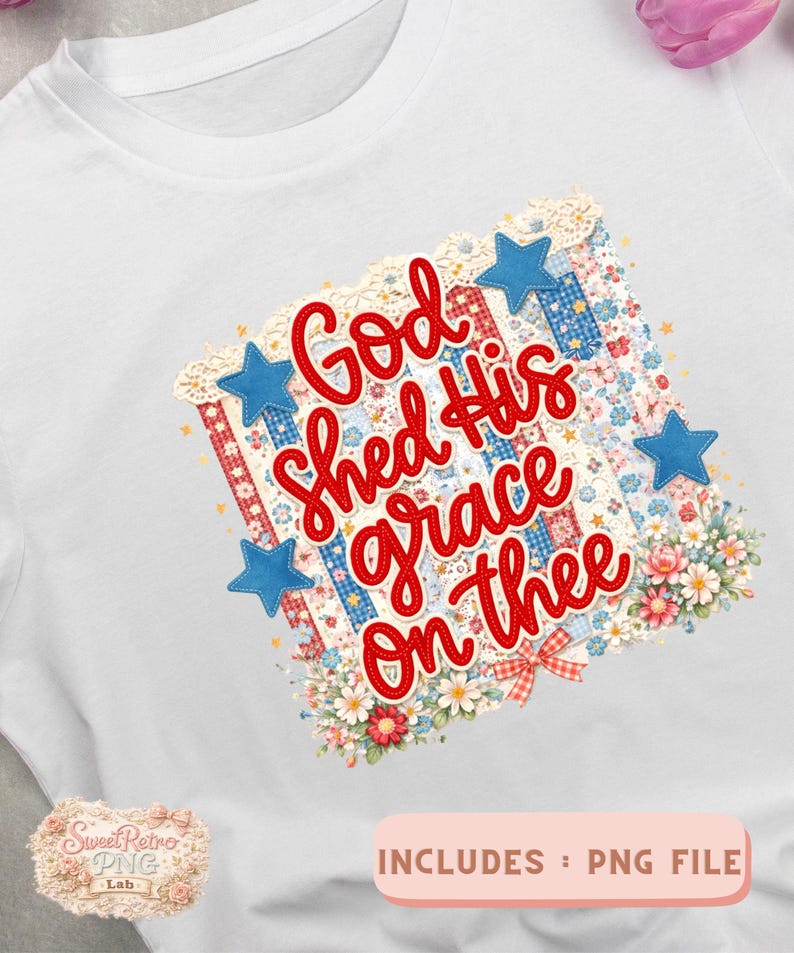 May include: White t-shirt featuring a patriotic design with the text "God shed His grace on thee" in red script. The design includes blue stars, floral accents, and a patchwork pattern.