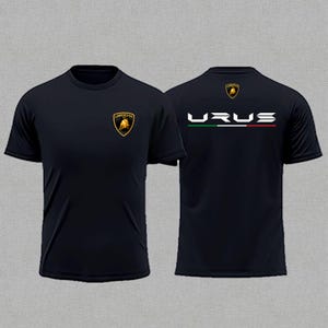 May include: Black t-shirt featuring the Lamborghini logo on the front and the word "URUS" with Italian flag colors on the back. The shirt has short sleeves and a crew neck.