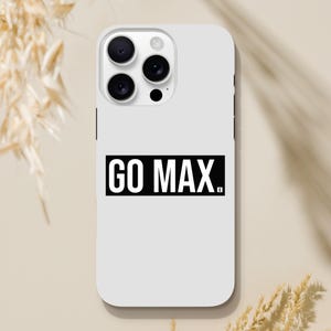 May include: A white phone case with a black rectangular design that reads "GO MAX." The case has a camera cutout with three lenses and a flash. The case is made of a smooth, glossy material.