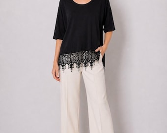 Top tipo túnica de punto elástico y fluido de Jostar, color negro, con dobladillo de borlas de encaje, estilo chic, talla 1X.