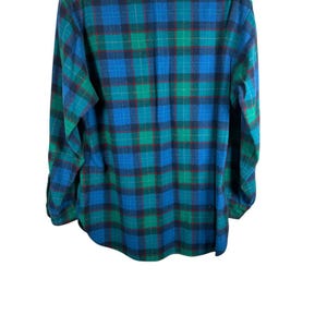May include: A long-sleeved flannel shirt in a classic plaid pattern. The shirt features a combination of blue, green, and red hues, creating a visually appealing design. The garment is made of a soft, possibly woven fabric, and is suitable for casual wear.