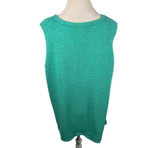 Puede incluir: Una camiseta sin mangas de punto verde esmeralda. La parte superior tiene un cuello redondo y un patr&oacute;n de punto texturizado. La prenda se exhibe en un maniqu&iacute;, mostrando su forma y dise&ntilde;o. La tela parece ser de peso medio, adecuada para varias estaciones.