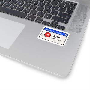 Könnte beinhalten: Ein rechteckiger Aufkleber mit einem Computer-Fehlermeldungs-Design, einer blauen Titelleiste mit der Aufschrift MYWILLTOLIVE.COM, einem roten Kreis mit einem weißen X und dem schwarzen Text 404 Not found!, angebracht auf einer Laptop-Tastatur.