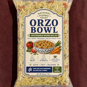May include: A clear plastic bag of Natasha's Pierogi Orzo Bowl, a Mediterranean-inspired meal mix. The label features text and illustrations of ingredients like tomatoes and carrots. The package states it makes 2 servings and weighs 2.1 oz.