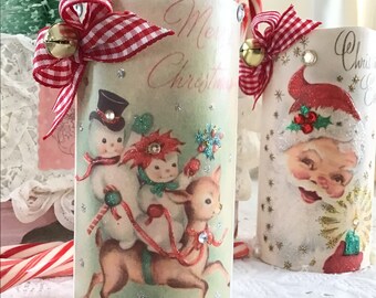 May include: Two vintage Christmas themed candle holders. One features a snowman and a deer with the text "Merry Christmas". The other features Santa Claus with the text "Christmas Eve".