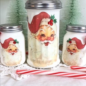 May include: Set of three white ceramic Santa Claus sugar dispensers with red and green accents. The dispensers have a vintage look and are perfect for adding a festive touch to your kitchen.