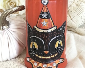 May include: Orange Halloween sugar dispenser with a black cat wearing a party hat and a rhinestone collar.
