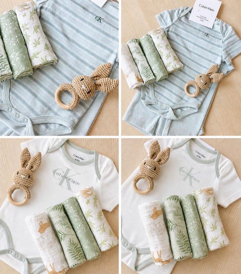 May include: Four-panel image of baby clothing sets. Each set includes a short-sleeved bodysuit with the Calvin Klein logo, a crocheted bunny ring, and three muslin cloths with botanical prints. The bodysuits are either white or light blue striped.