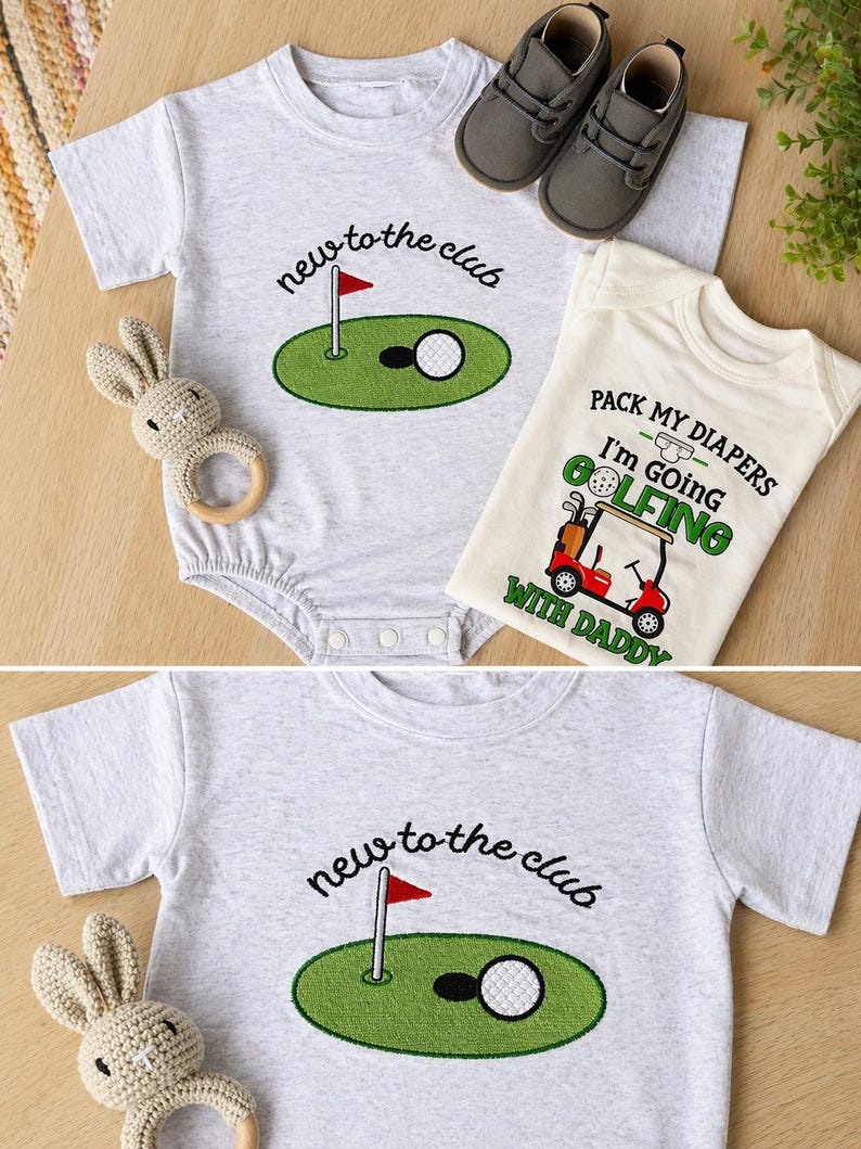 May include: Two baby onesies with golf-themed designs. One is gray with "new to the club" and a golf course graphic. The other is cream-colored with "Pack my diapers, I'm going golfing with daddy" text and a golf cart graphic. Gray baby shoes and a bunny rattle are also present.