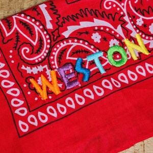 rainbow colored name embroidery. name embroidered on a paisley cowboy western bandana. party bandana, kids party bandana embroidery .