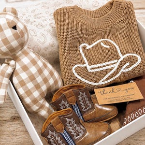Southern cowboy baby gift. New parents baby gift. Oklahoma baby gift. Wyoming baby gift. Montana baby gift. Michigan baby gift. Yellowstone theme baby gift. western Gift for new parents. Western baby announcement. Baby keepsake gift. Baby cowboy announcement. Baby due cowboy. yeehaw baby outfit. Baby gift box ready. regalo bebé vaquero.
regalo vaquero para bebé. botitas vaqueras bebé. Gift box ready new born gift. Gift ready baby hamper.