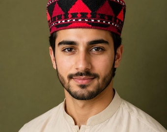 May include: A cylindrical cap featuring a vibrant geometric pattern in shades of red and black. The design consists of repeating triangular shapes around the circumference, accented with thin white horizontal lines and intricate embroidery details.
