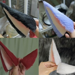 以下が含まれることがあります： 黒、水色、濃い赤、白のフェイクファーで作られた4組の動物の耳のコレクション。各ペアは三角形の形状をしており、柔らかく豪華な質感と、対照的な明るい色の内耳部分が特徴で、コスチュームアクセサリーとしてデザインされています。