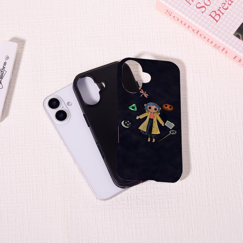 May include: A black phone case featuring a cartoon character in a yellow coat and blue hair, with various small graphic elements. A white phone and a black phone case are next to it. The phone cases are on a white surface.