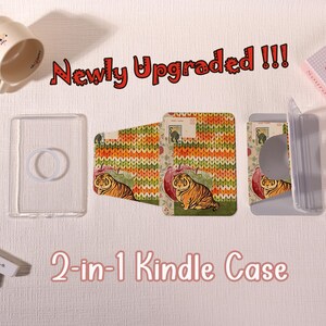 Può includere: Una custodia Kindle 2-in-1 composta da un guscio trasparente con anello di supporto e una cover separata con sfondo a motivo lavorato a maglia, una mela rossa e un'illustrazione di tigre. Il testo "Newly Upgraded !!!" e "2-in-1 Kindle Case" è visibile.