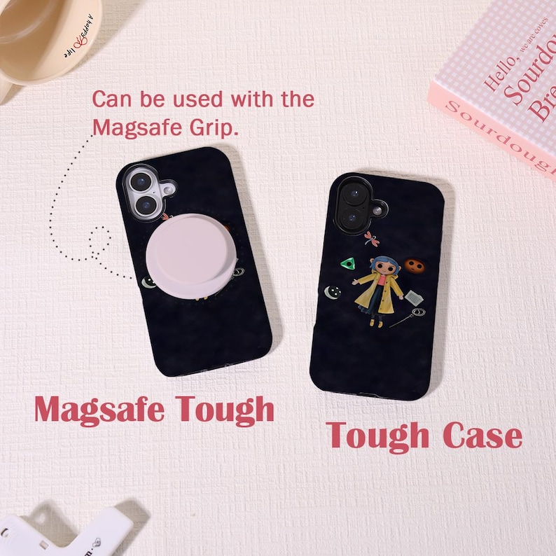 May include: Two black phone cases with unique designs. One features a light pink MagSafe grip, the other a cartoon character. Text on the cases reads "Magsafe Tough" and "Tough Case." The cases are shown on a light-colored surface.