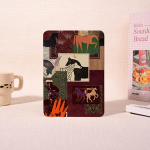 Könnte beinhalten: Eine rechteckige Karte mit einer Collage aus verschiedenen Pferdeillustrationen, darunter ein schwarzes Pferd, ein orangefarbenes Pferd und ein geflecktes Pferd. Das Design enthält dunkelrote, dunkelgrüne und goldene Muster sowie eine orangefarbene Hand.