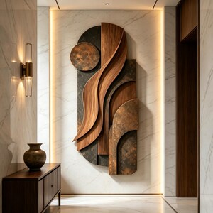 May include: A large vertical wall sculpture featuring layered wood panels with flowing, curved grain patterns and dark, textured metallic elements. The piece is mounted on a white marble wall illuminated by vertical LED strips on both sides.