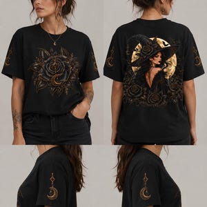 May include: A black short-sleeved t-shirt featuring a large graphic of a dark rose with a crescent moon on the front. The back displays a witch wearing a wide-brimmed hat against a full moon, surrounded by roses. Each sleeve features a crescent moon charm.