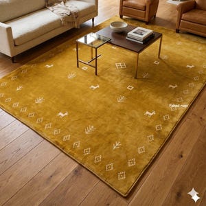 May include: A large rectangular area rug in a deep mustard yellow color featuring a repeating pattern of small white geometric shapes, stylized trees, and animal figures. The text "Fahad rugs" is printed in white on the lower right side.