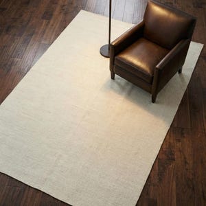 Puede incluir: Una tabla de cortar de madera hecha a mano con un acabado natural. La tabla presenta un borde natural en un lado y una forma rectangular lisa. Mide aproximadamente 45 cm de largo, 30 cm de ancho y 2,5 cm de grosor.