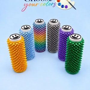 Peut inclure: Six rouleaux cylindriques à picots disposés en demi-cercle, chacun surmonté d'un capuchon blanc circulaire avec un visage souriant noir. Les rouleaux sont jaune, bleu, dégradé arc-en-ciel, argenté, violet et vert. Texte : Choose your colors.