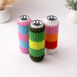Puede incluir: Un juego de tres tazas de cerámica con acabado moteado y mate. Las tazas son de color crema, gris claro y gris oscuro. Cada taza tiene un diseño simple y moderno y un asa redondeada.