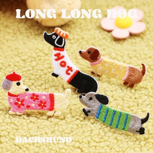 May include: Embroidered dachshund patches in various colours and designs. One patch features the word "Hot" on the dog's body. The patches are on a textured yellow surface. The text "LONG LONG DOG" and "DACHSHUND" are also visible.