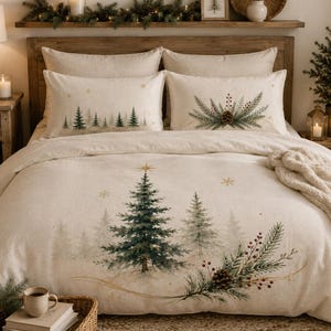 Peut inclure: Une housse de couette couleur crème et deux taies d'oreiller assorties présentant une scène de forêt hivernale imprimée avec des sapins verts, des pommes de pin brunes, des baies rouges et des étoiles dorées. L'ensemble affiche un aspect doux.