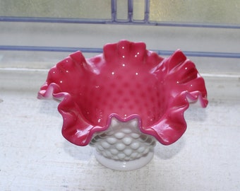 May include: A white milk glass bowl with a pink ruffled rim. The bowl has a textured, bubbled surface.