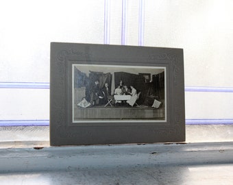 Fotografía de una escena de una obra de teatro en una tarjeta de gabinete antigua